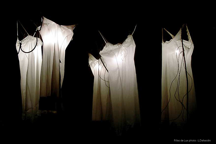 art light installation night dresses hanging in the light