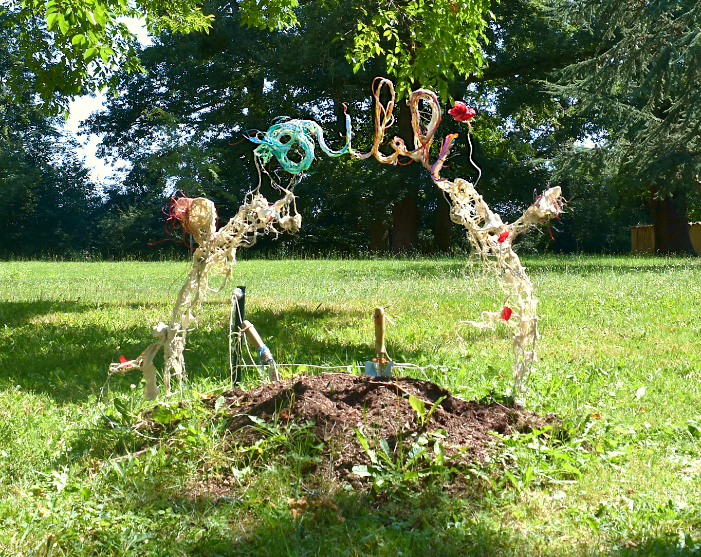 Piet.sO, - sculpture installation contemporaine, jardin du château d'Aulteribe - exposition personnelle loci par ci et mes mémoires d'oiseaux au château d'Aulteribe, Auvergne. Le public est invité à enterrer un souvenir douloureux  dans le tertre de l'installation; Les lettres oubli sont formées sur une grille métallique par des câbles et résine acrylique .