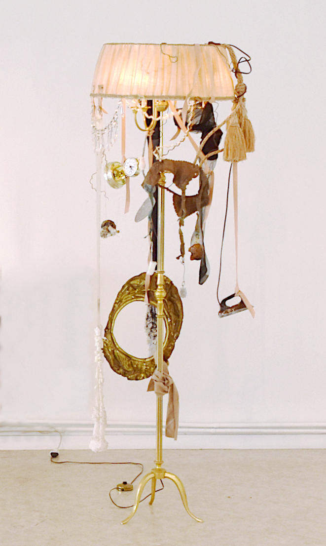 art contemporain et temps. Lampanar est une sculpture installation contemporaine composite de Piet.sO, lampadaire avec abat-jour en tissus, pièces de sous-vêtements cristallisés par le sel ou électrolysés, objets cristallisés par le sel, pendulette, sous-vêtements, bas, porte-jarretelles. 